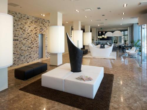 a lobby with a vase on a white table at Grand Hotel Mattei in Ravenna