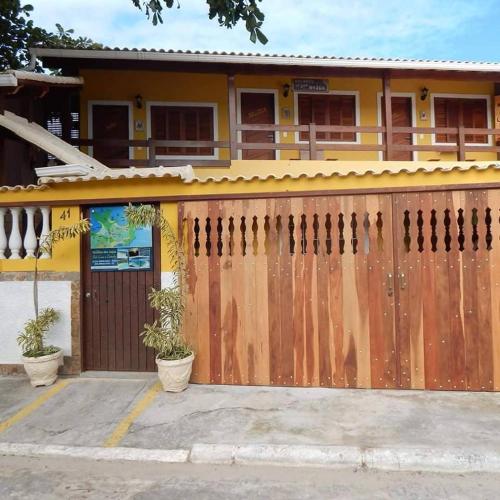 a wooden fence in front of a house at Estúdio Recanto Dos Anjos in Arraial do Cabo