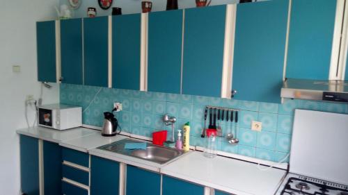 a blue kitchen with a sink and a counter top at Svit Dovolenkový dom in Svit