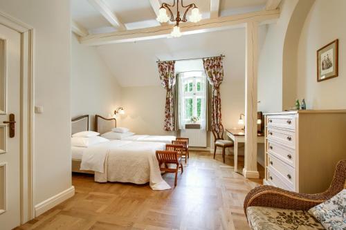 sypialnia z łóżkiem, stołem i krzesłami w obiekcie Pałac Zdunowo w mieście Załuski