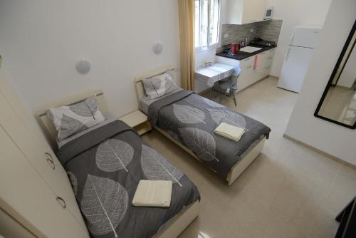 2 camas en una habitación pequeña con cocina en Olga Beach Apartment 28, en Haifa