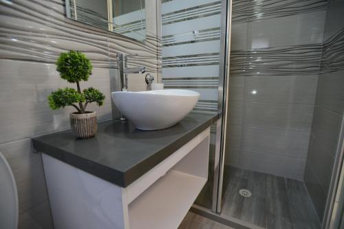 Un baño con un lavabo blanco sobre una encimera. en Olga Beach Apartment 28, en Haifa