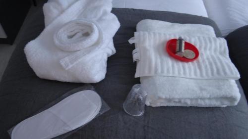 a pile of towels and a red ring on a bed at Maison 88 m2 le patio du centre ville avec garage in Tours