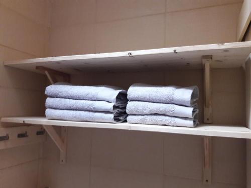 un grupo de toallas en un estante del baño en La Coulée Douce - Chez Antoine en Castelnaudary