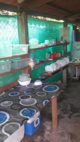 a kitchen with a bunch of plates on a table at Johnny Fiestas in Las Lajas