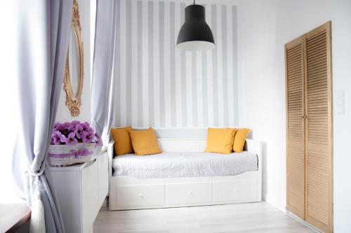 a white bedroom with a white bed with orange pillows at Apartament LOFT Glamour EC1 in Łódź
