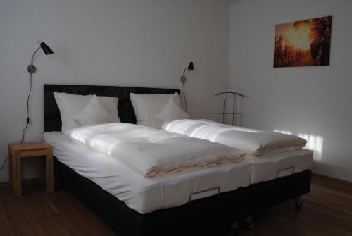 a large bed with white sheets and pillows on it at FEWO am Weinmarkt in Bad Windsheim