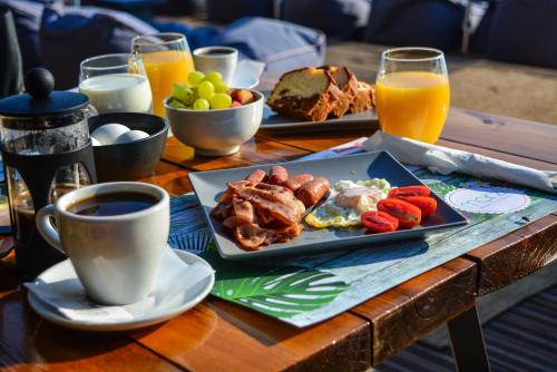 a table with a plate of food and a cup of coffee at Marzi Boutique Hotel in Nerátza