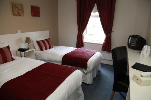 a hotel room with two beds and a window at Dalton Inn Hotel in Claremorris