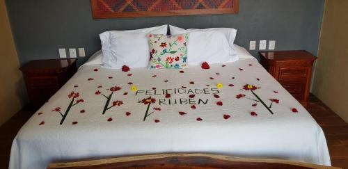 a bed with a floweridered blanket on it at Casa Arcoiris Zihuatanejo B&B in Zihuatanejo