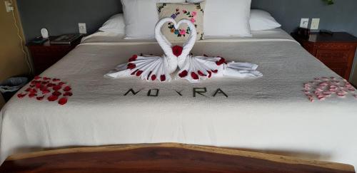 a bed with a swan made out of red pedals at Casa Arcoiris Zihuatanejo B&B in Zihuatanejo