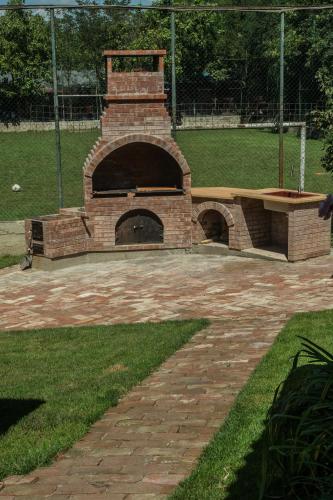 a brick oven in a park with a brick path at Enpi Lake Resort in Iaşi