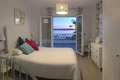 a bedroom with a bed with a view of the ocean at Apartamentos en Paseo Maritimo in El Rompido