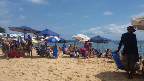 un grupo de personas sentadas en una playa con sombrillas en Temporada, en Salvador