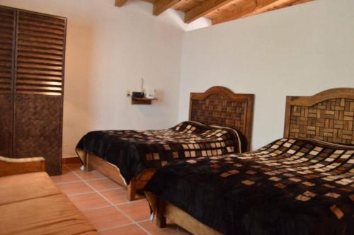a bedroom with two beds and a couch at Betos Departamentos in Valle de Bravo