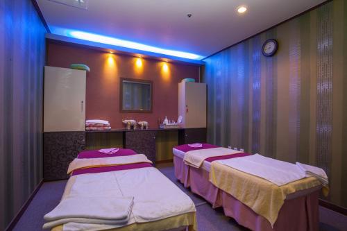 two beds in a hospital room with blue lights at Jeju Ilsung Beach Condo in Jeju