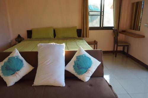a couch with two pillows on it in a bedroom at Kwainoy Riverpark in Sai Yok