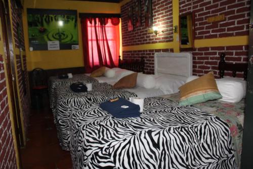 two beds in a room with a zebra print at Hotel Casa Del Viajero in Quetzaltenango