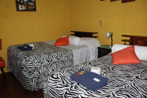 a hotel room with two beds with towels on them at Hotel Casa Del Viajero in Quetzaltenango