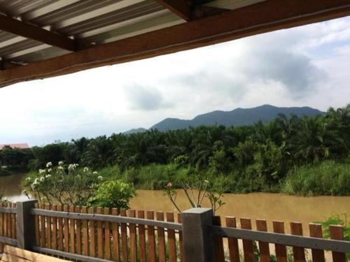a wooden fence with a view of a river and mountains at Teak villa in Thoeng