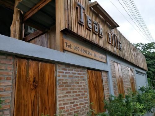 a building with wooden doors and a sign on it at Teak villa in Thoeng