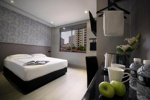 新加坡Hotel Classic by Venue的酒店客房,配有一张床和一张苹果桌