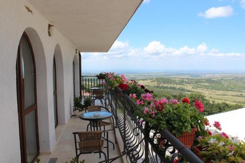 a balcony with flowers and a table and chairs at Zaara Estate Winery Hotel & SPA in Glavan