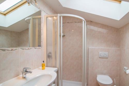 a bathroom with a shower and a sink and a toilet at Hotel Sonnenhof in Lana