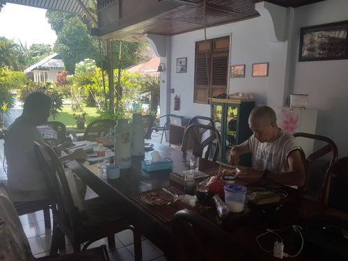 een man aan een tafel in een restaurant bij Sendowan Baru Amurang in Amurang