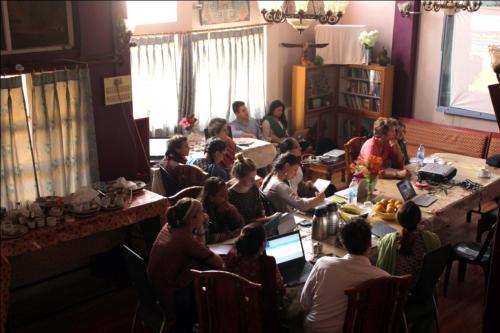 a group of people sitting around a table in a room at Sahi River View Guest house in Varanasi