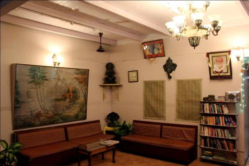 a living room with couches and a large painting on the wall at Sahi River View Guest house in Varanasi