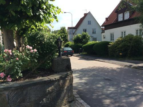 a street with a stone wall and a car driving down a street at Pia's House in Gothenburg