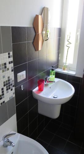 a bathroom with a white sink and a mirror at Idria B&B in Barcellona-Pozzo di Gotto
