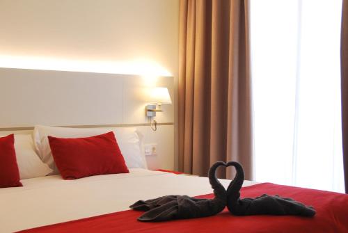 a pair of swans are sitting on a bed at Hotel Pompaelo Plaza del Ayuntamiento & Spa in Pamplona