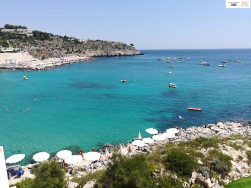 a beach with umbrellas and boats in the water at Le Strazzigne in Marittima