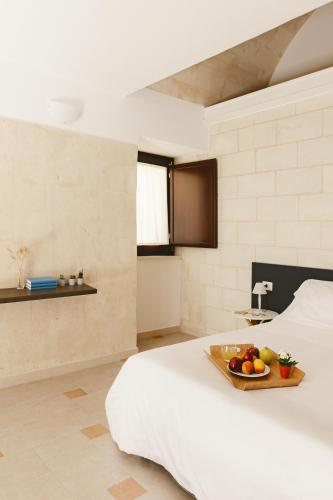 a bedroom with a bed with a tray of fruit on it at Il Borgo Ritrovato - Albergo Diffuso in Montescaglioso