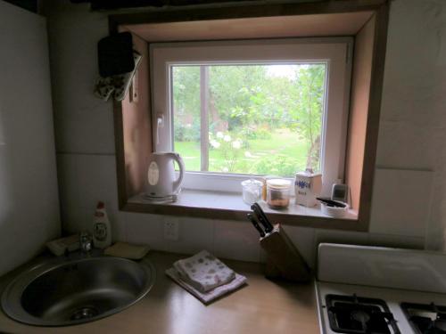 uma cozinha com um lavatório e uma janela em Peters House em Iecava