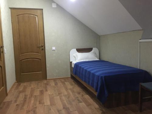 Dormitorio pequeño con cama con manta azul en Zarya Hotel en Khorog