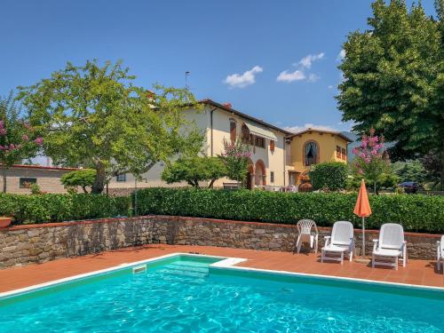 a swimming pool with chairs and a house at Agriturismo Bellosguardo in Reggello