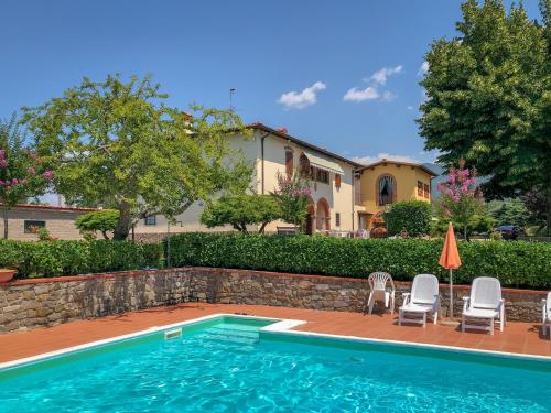 - une piscine avec des chaises et une maison dans l'établissement Agriturismo Bellosguardo, à Reggello