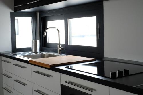 a kitchen with a sink and two windows at Sunset Apartment at Casilla de Costa in Villaverde