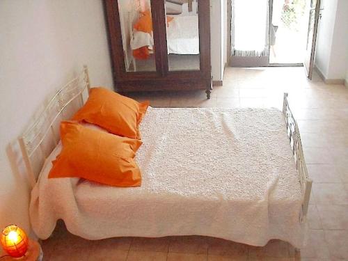 Roglianoにあるa casettaの白いベッド(オレンジ色の枕付)