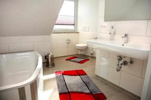 a white bathroom with a sink and a toilet at Ferienwohnung „Kranich“ in Mirow