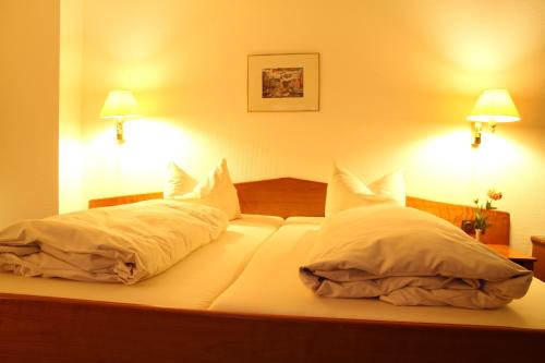 a bedroom with a bed with two pillows at Hotel "Die Kupferpfanne" in Donaustauf
