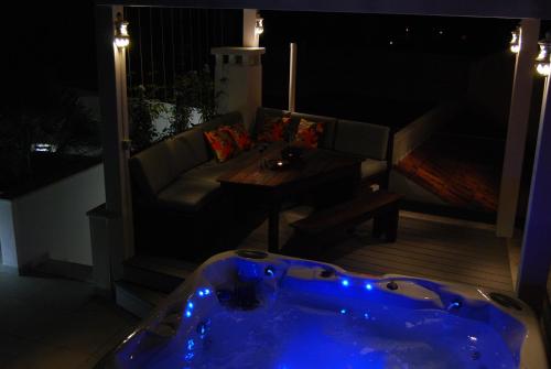 a jacuzzi tub sitting on a balcony at night at The Birds Nest in Alvor