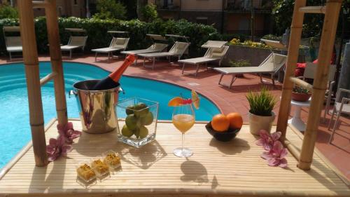 uma mesa com comida e bebidas junto a uma piscina em My Place Hotel em Rimini