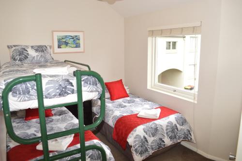 una piccola camera con letto a castello e finestra di Akaroa Central Apartment ad Akaroa