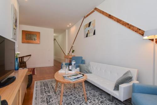 a living room with a white couch and a table at Oporto Lovely House in Porto