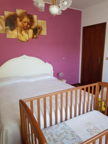 a bedroom with a crib and a purple wall at Relax da Sabry in Senigallia