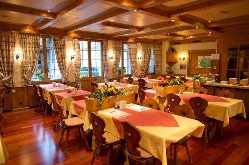 a dining room filled with tables and chairs at Sporthotel Victoria in Gstaad